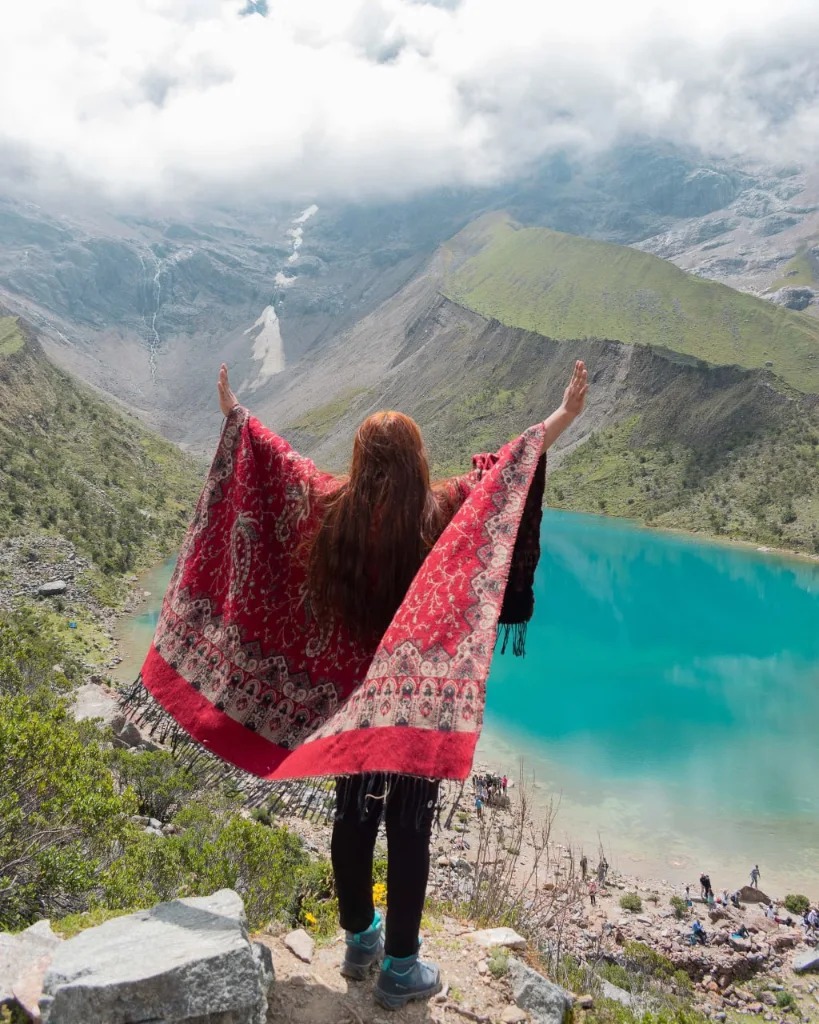 Laguna Humantay con su característico color turquesa brillante, rodeada de montañas imponentes y paisaje alpino.